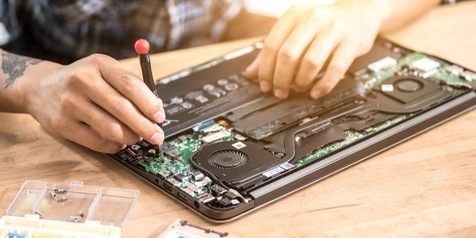 A tech repairing a laptop computer