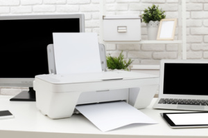 A white desk holds a printer, copier, and scanner: concept, computer peripherals, and hardware.