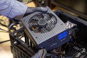 A computer technician is putting a power supply unit into a computer. A power supply unit tier list can help individuals select the best option for their needs, ensuring optimal performance, efficiency, and reliability in their builds.